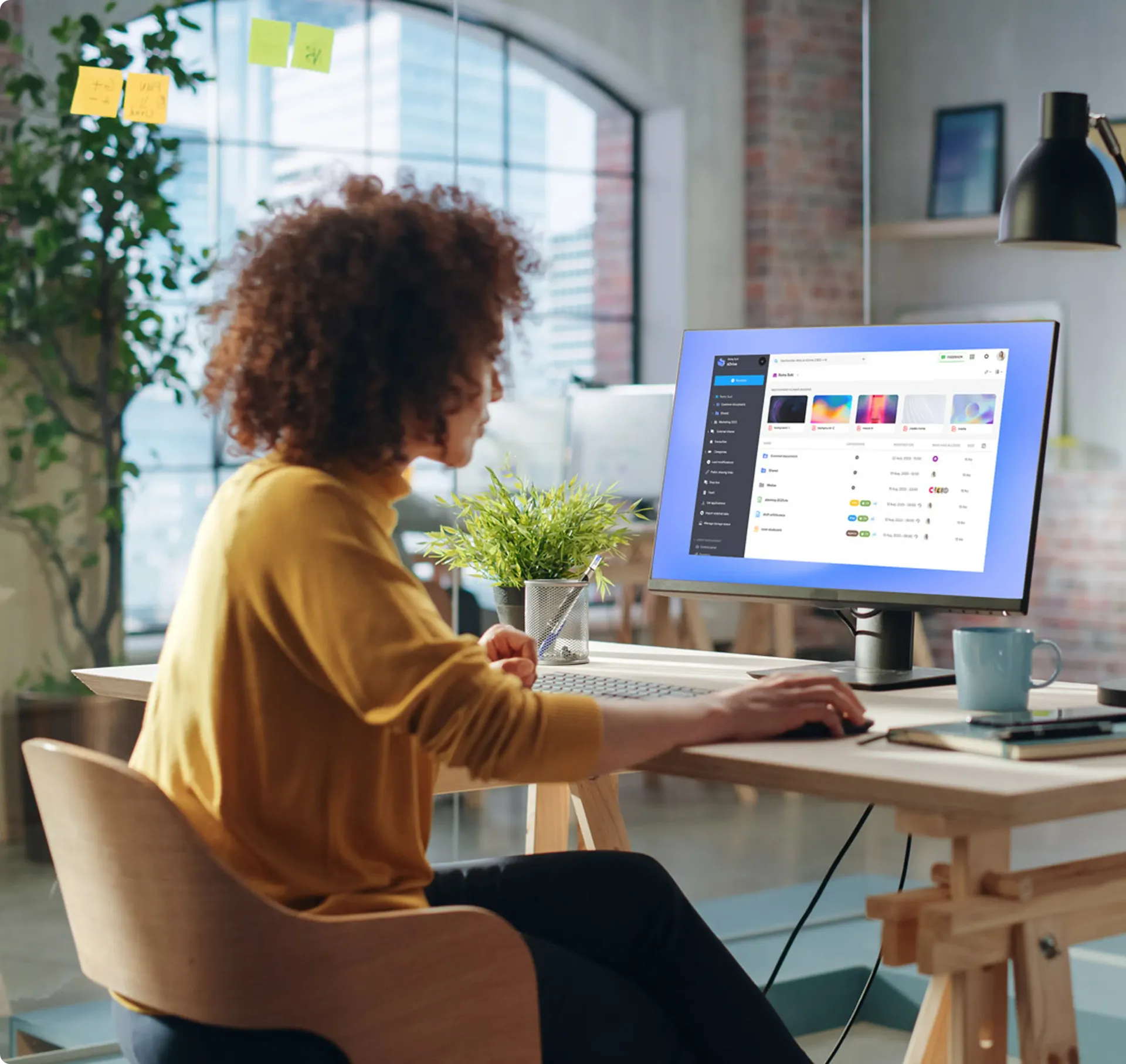 Image d'une personne utilisant un ordinateur dans un bureau pour représenter un environnement de travail sécurisé.