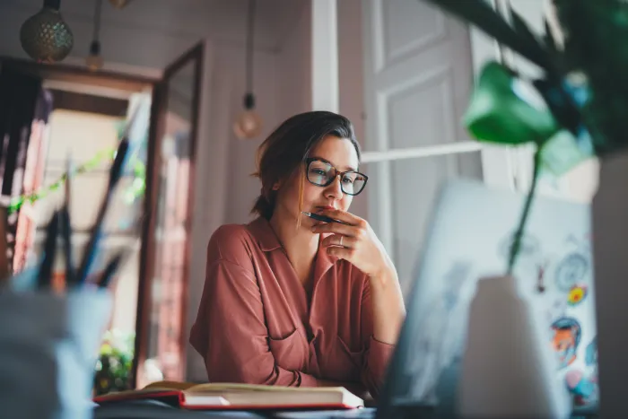 Image représentant une femme travaillant sur son ordinateur portable, illustrant l'accès aux fichiers en déplacement avec la possibilité de consulter, modifier et partager des documents depuis un mobile ou un ordinateur.