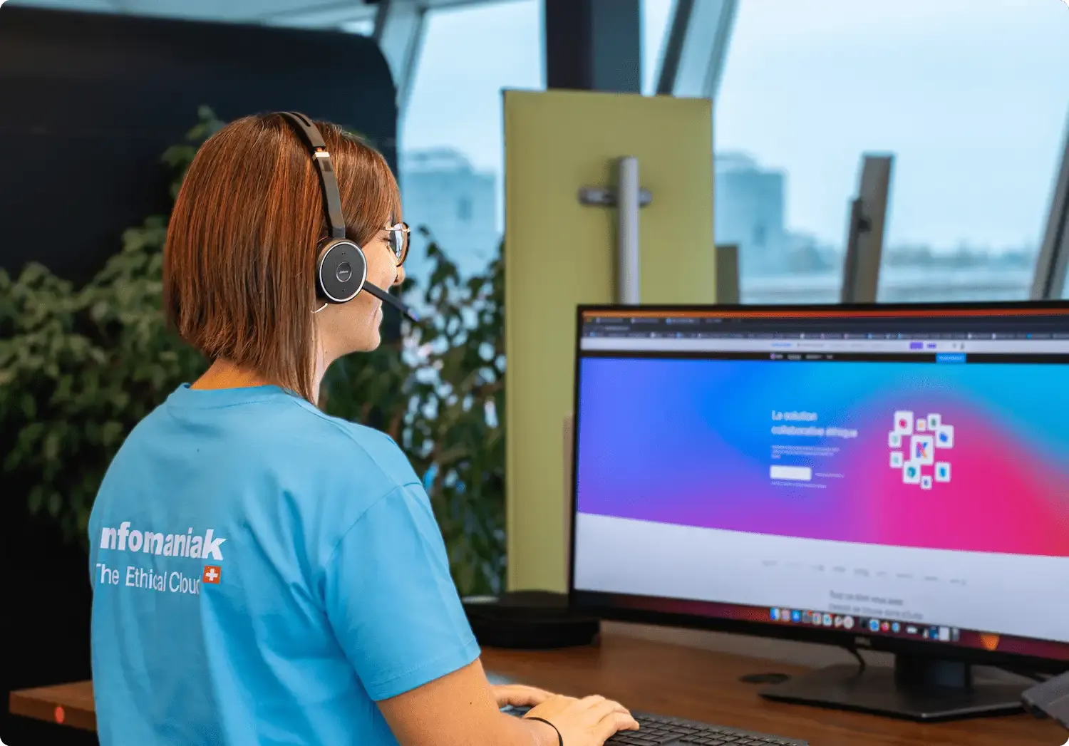 Image d'une agent de support d'Infomaniak au téléphone affichant un grand sourire